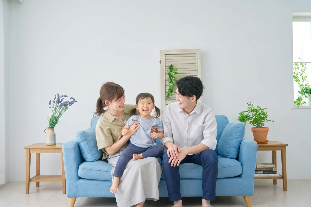 青いソファに座って笑顔で過ごす親子3人